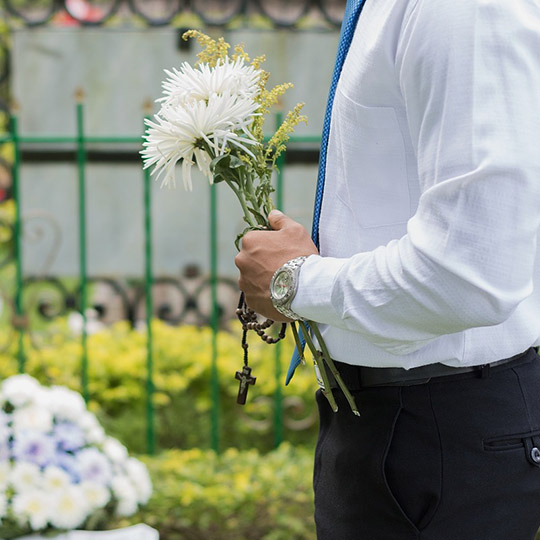 Homme tenant un chapelé et un bouquet de fleurs